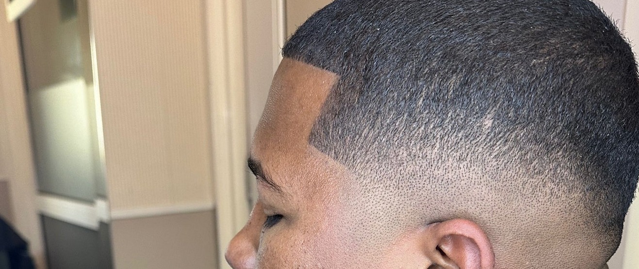 Skin fade met een strakke contour langs de haarlijn, close-up