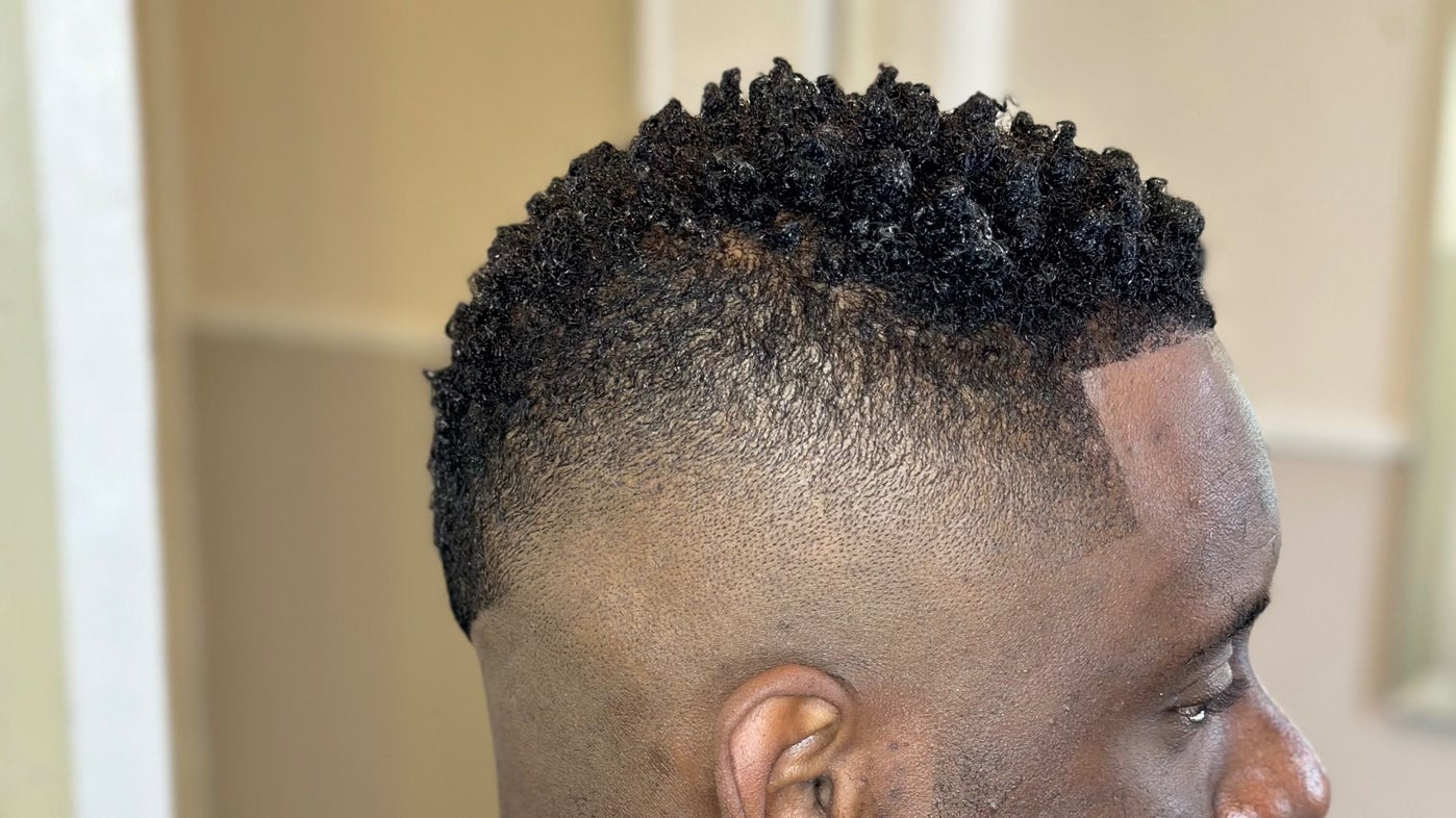 Hoge fade met textuur bovenop, van opzij gezien
